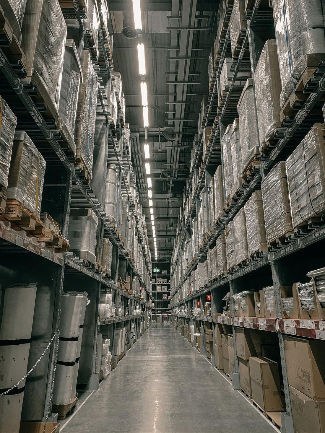 Long warehouse aisle with tall racking and stored goods on both sides